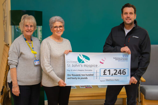 Three people holding up a cheque for £1246