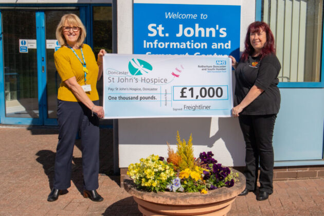 Two people holding a cheque