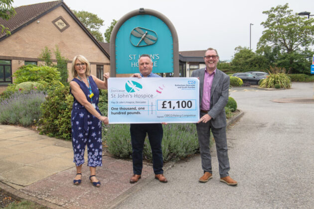 Three people holding up a cheque for £1,100