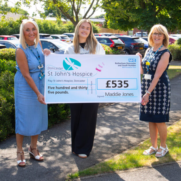Three people holding up a cheque for £535
