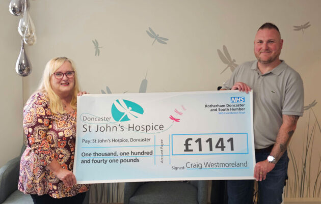 Two people holding up a cheque for £1,141