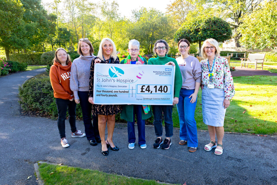 Seven people next to a cheque for £4,140