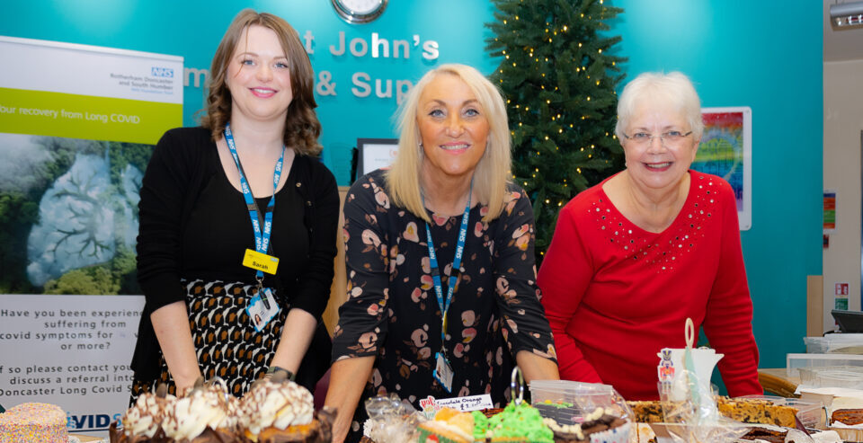 Staff and volunteers around a table of food
