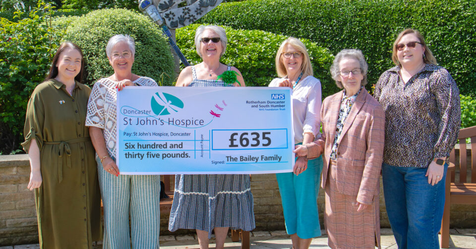Six people holding up a cheque for £625
