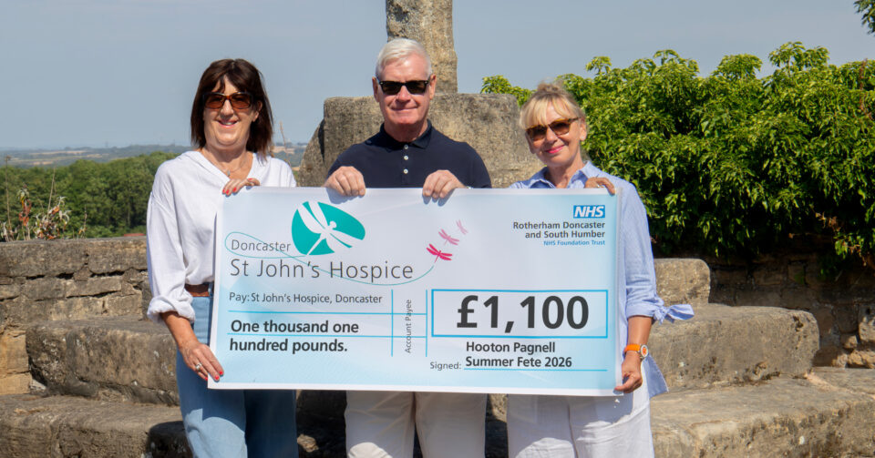 Three people holding up a cheque for £1,100