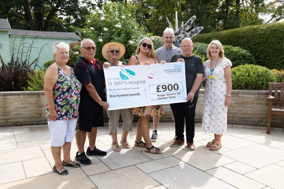 Roger and friends holding a £900 cheque with Tracey Gaughan