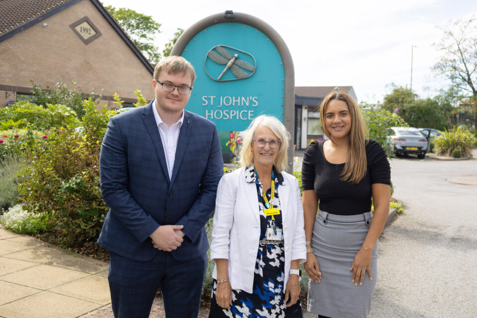 Three people in front of St John's Hospice